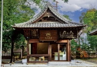 さいたま市大宮区の「氷川茶庭」の店舗外観。伝統的な和風建築の屋根と木彫りの装飾が施された、お茶屋の趣のある建物。周囲は緑に囲まれている。