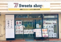 77Sweets shop 春日部中央店の外観。8月20日NEW OPENの告知とアイス販売に関する案内が確認できる。